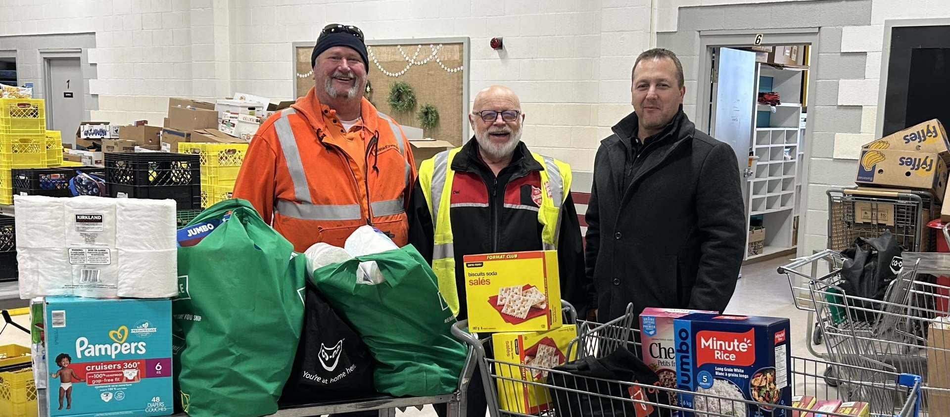 Three people stand in a food bank
