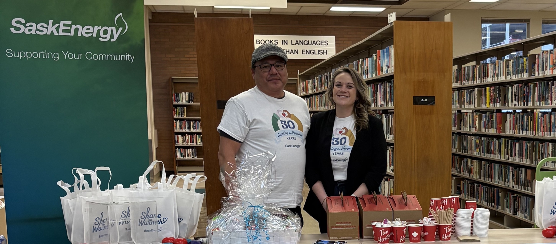 Two people by a table and banner