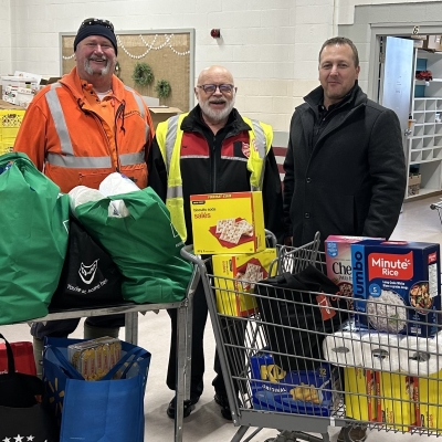 Three people stand in a food bank