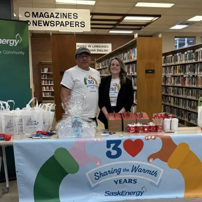 Two people by a table and banner