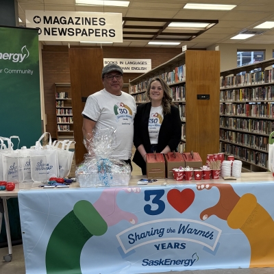 Two people by a table and banner
