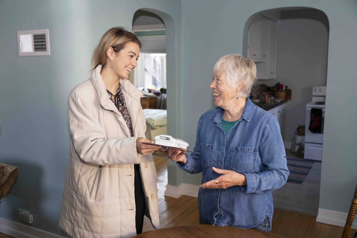 Daughter hands mother carbon monoxide detector Daughter hands mother carbon monoxide detector