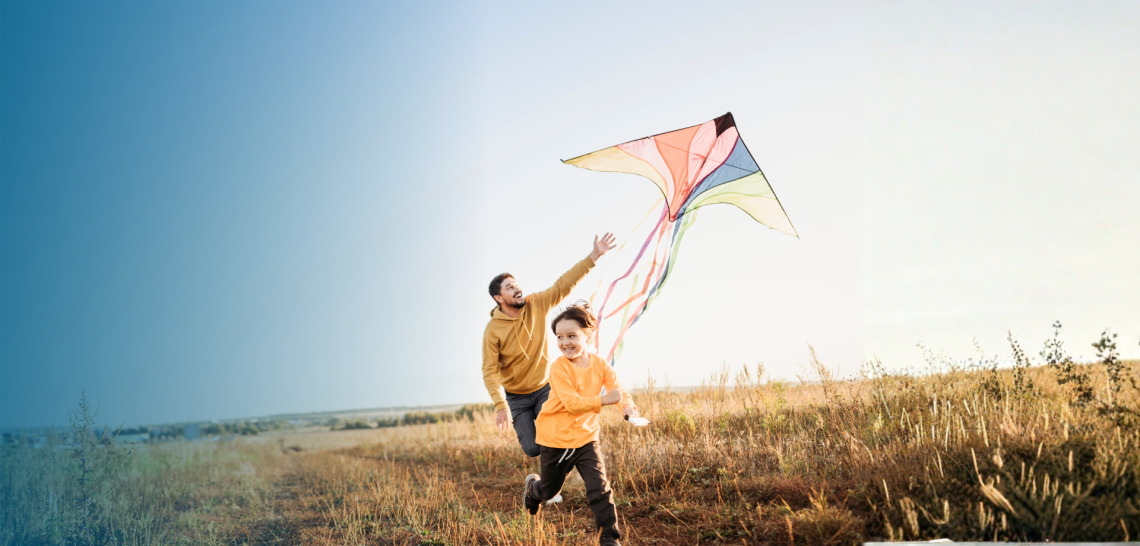 Adult and child flying kite outside