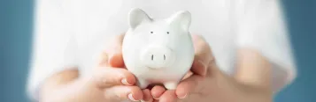 Female hand holding piggy bank