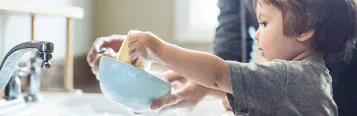 child washing dishes